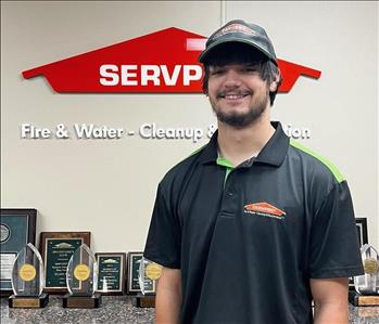 SERVPRO employee in front of orange sign