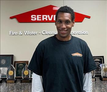 SERVPRO employee in front of orange sign